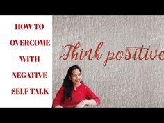 a woman standing in front of a wall with the words think positive