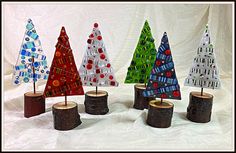 four small christmas trees made out of wood logs