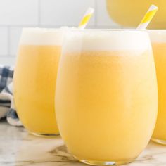 three glasses filled with orange juice on top of a counter