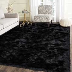 a living room with a white couch and black shaggy rug on the floor in front of a window