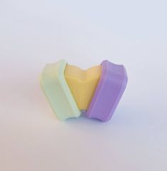 two heart shaped soap bars sitting next to each other on a white surface with no one around them