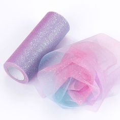 two rolls of pink and blue organe tulle next to each other on a white surface