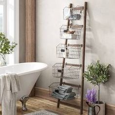 a white bath tub sitting under a window next to a shelf filled with pots and pans