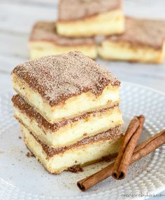 three pieces of cake on a plate with cinnamon sticks