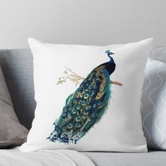 a blue and green peacock sitting on top of a white pillow with gold trimmings