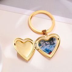 two heart shaped key chains on top of a white table with a cup and saucer in the background