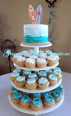 a three tiered cake and cupcake display on a table