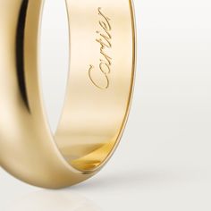 a gold wedding ring with the word love engraved on it