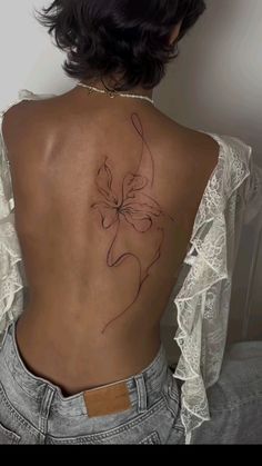 a woman's back with a flower tattoo on it