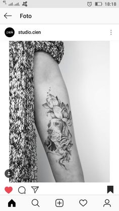 a black and white photo of a woman's arm with flowers tattooed on it