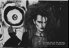 a black and white photo of a woman with long hair in front of a wall