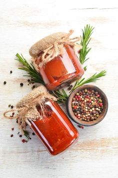 two jars filled with red liquid and spices