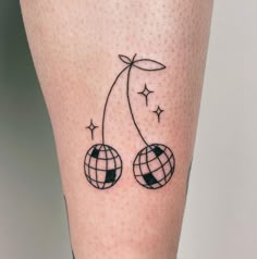 a tattoo on the leg of a woman with two balls