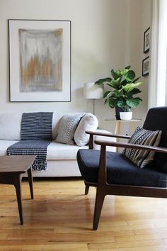 a living room filled with furniture and a painting on the wall