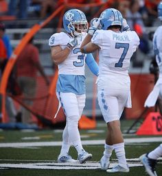 two football players standing next to each other on a field