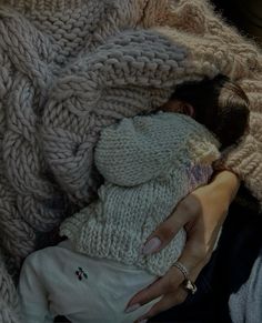 a woman holding a baby wrapped in blankets