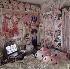 a room filled with lots of stuffed animals next to a laptop on top of a bed