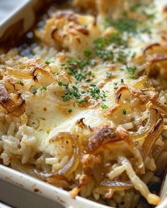 a casserole dish with onions, cheese and parsley