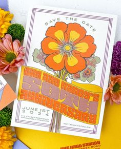 an orange and yellow flower on top of a white card with the words save the date