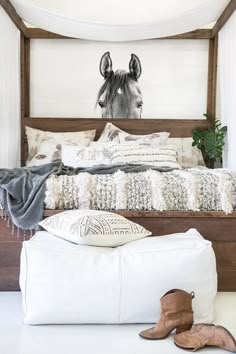 a bedroom with a horse head on the wall above the bed and pillows below it