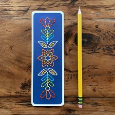 a pencil sitting on top of a wooden table next to a bookmark