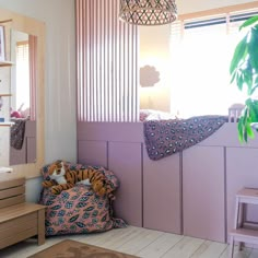 a child's bedroom with pink walls and wooden flooring