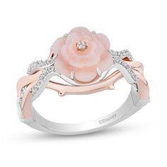 a pink rose ring with white diamonds on the sides and two tone gold leaves around it