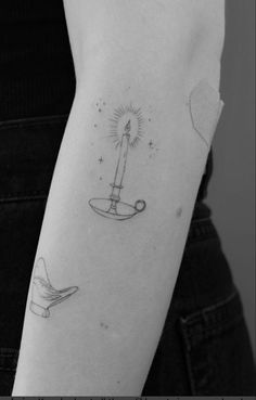 a woman's arm with a tattoo on it and a candle in the middle