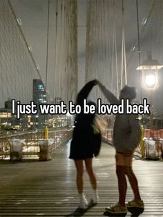 two people standing on a bridge with the words i just want to be loved back