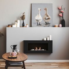 a living room with a fire place and two geese on the wall next to it