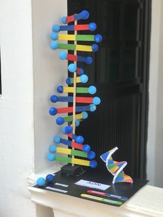 a colorful sculpture on top of a white mantle next to a black door and window