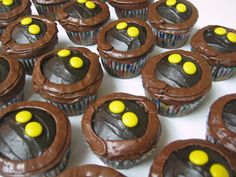 cupcakes with chocolate frosting and yellow candies in the shape of an eye