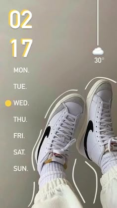 a pair of white nike sneakers sitting on top of a table next to a clock