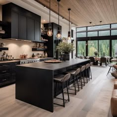 a large kitchen with lots of counter space and chairs around the island in front of it