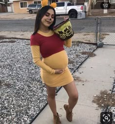 a pregnant woman dressed as winnie the pooh is posing for a photo in her costume