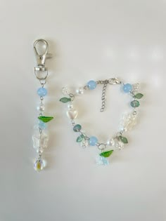 a bracelet with beads and charms hanging from it's side on a white surface