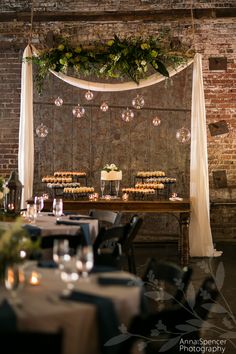 a table with cupcakes on it in front of a brick wall