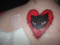 a woman with a heart shaped tattoo on her shoulder