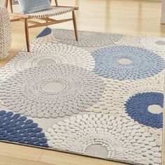 a blue and white area rug in a living room with two chairs next to it