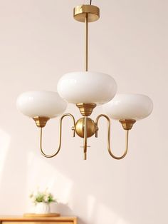 a chandelier hanging from the ceiling in a room with white walls and furniture