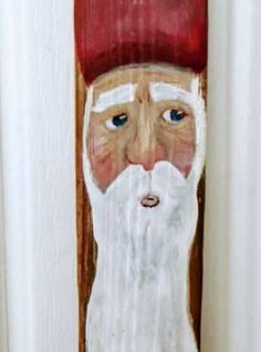 a painting of an old man with a beard and red hat on the door handle