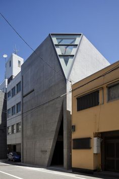 an unusual building with a triangular roof on the corner