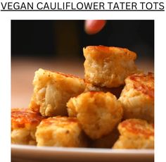 there is a white plate that has some tater tots on it and the words vegan cauliflower tater tots