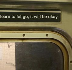 a sign that is on the side of a train door saying to learn to let go, it will be okay