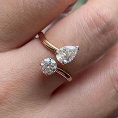 a woman's hand with two engagement rings on it