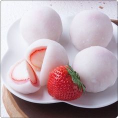 a white plate topped with fruit next to two eggs and a strawberries on top