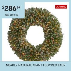 a christmas wreath with lights on it and the words nearly natural giant flocked faux