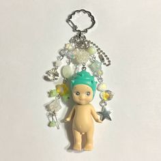 a keychain with a small doll on it's side and charms attached to it