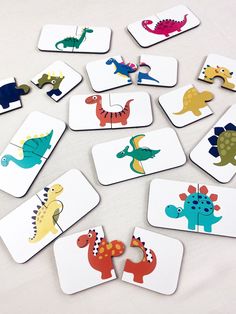 a bunch of coasters with different colored dinosaurs on them and one has a missing piece in the middle