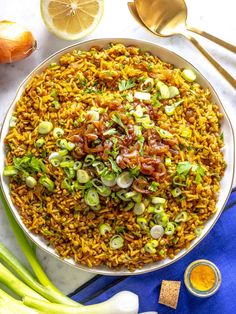 a bowl filled with rice, onions and celery on top of a table